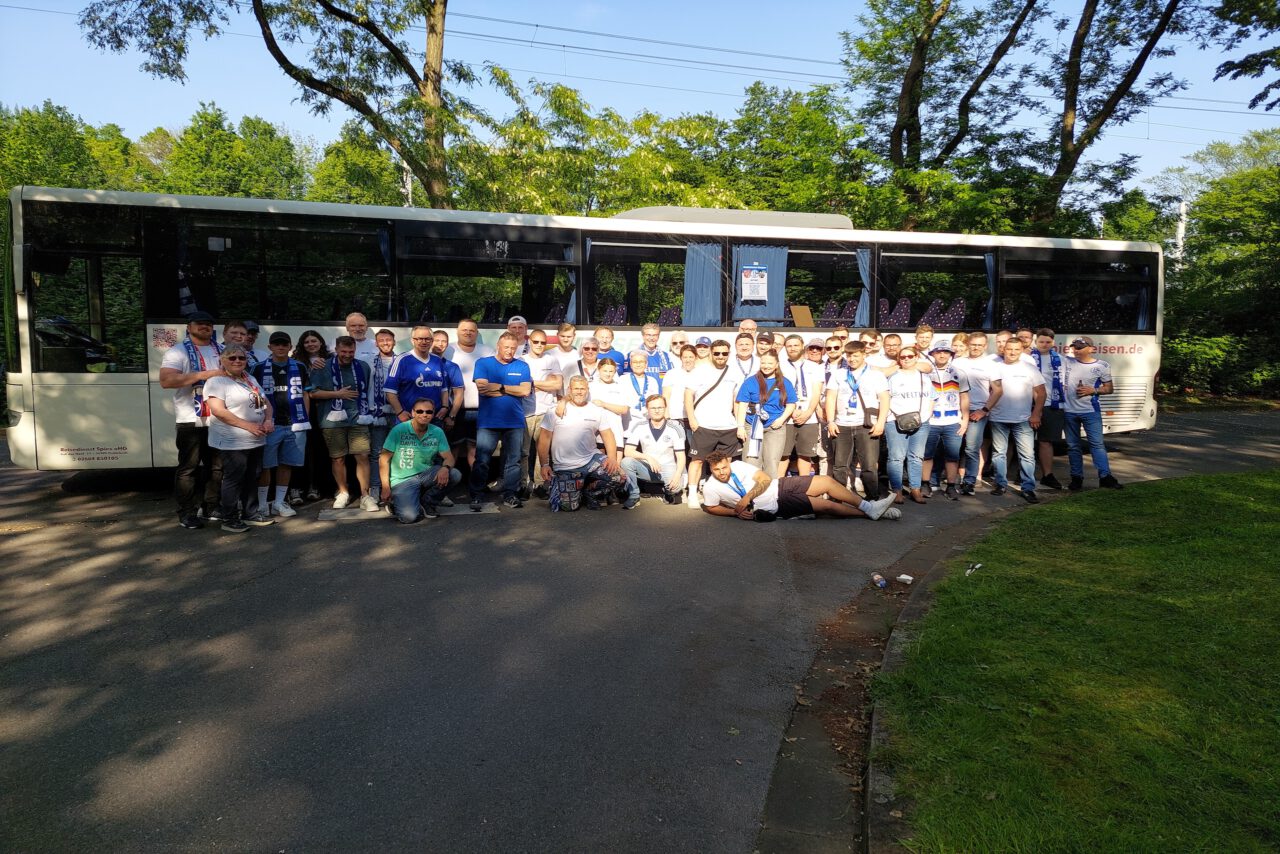 20240511_174217 Zu sehen ist eine Gruppe von Mitglieder der Vettelschosser Knappen 2002 e.V. die vor einem weißen Bus stehen.